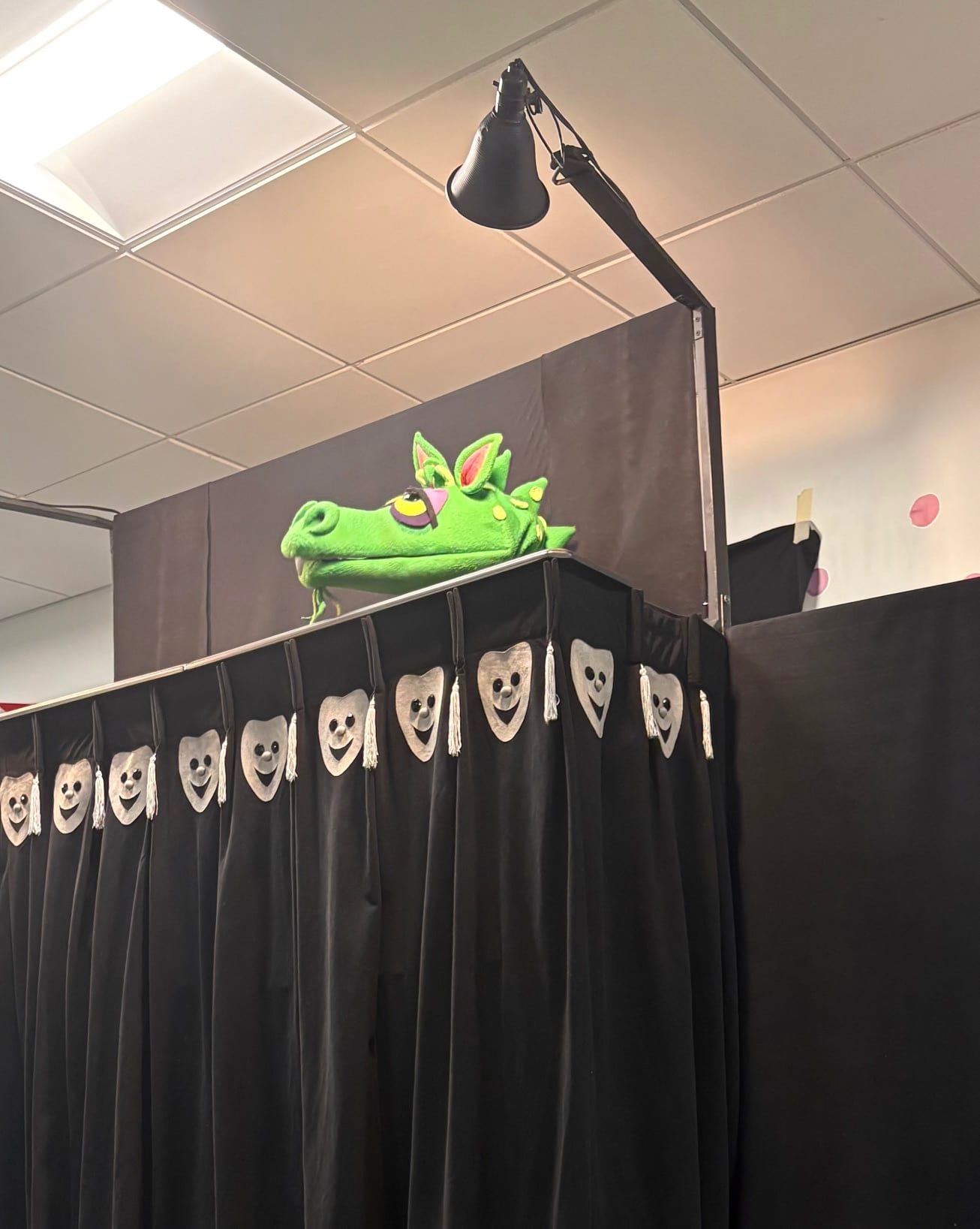 The dragon puppet peeking over the stage at the Pumpernickel Puppet Man show