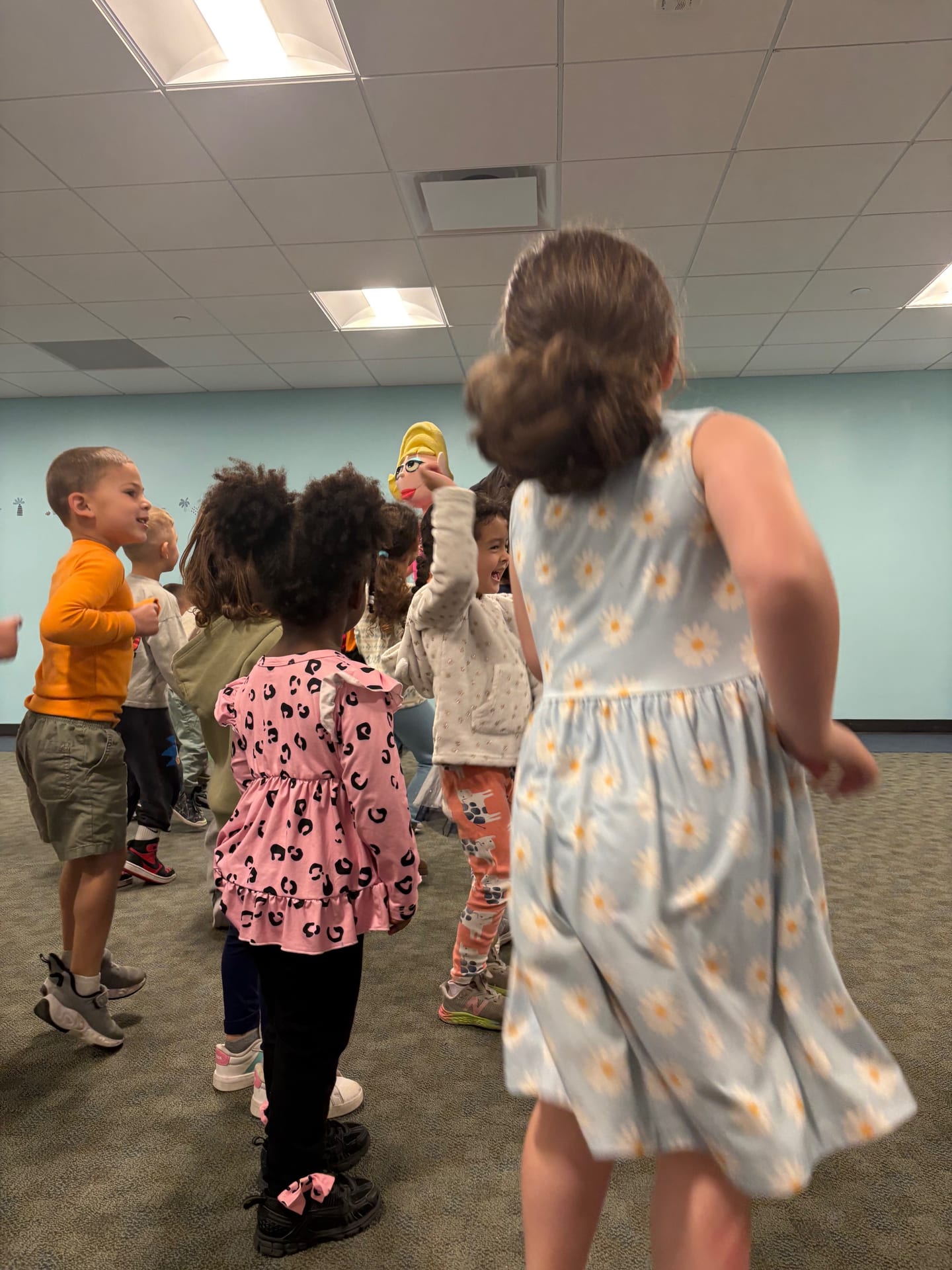Children dancing with a puppet in the indoor gym at Mountainside Children's Center